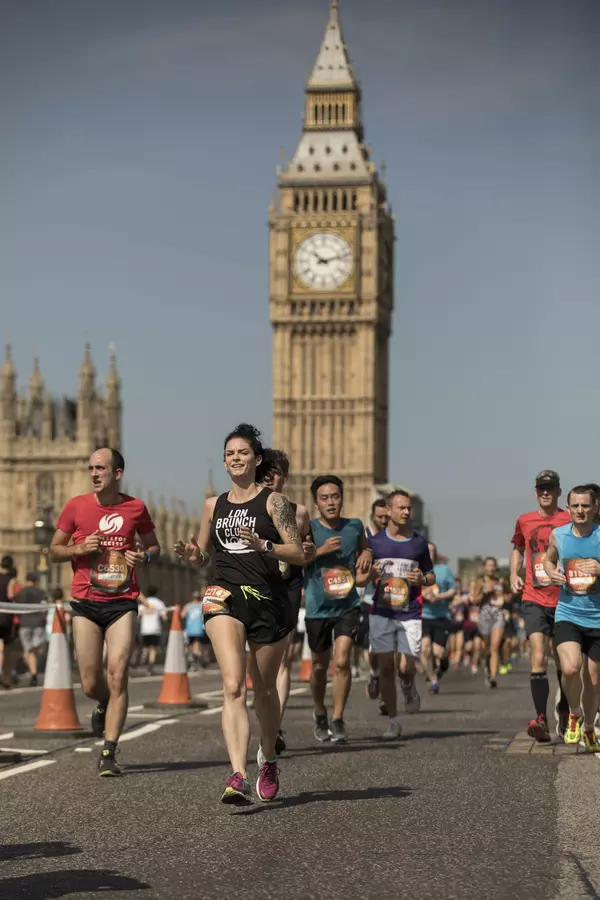 a group of runners running past Big Ben, London, as part of the Asics London 10k race