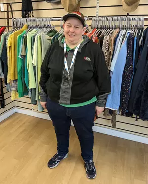 Retail Shop Assistant volunteer Taz poses for a photo in a charity shop.