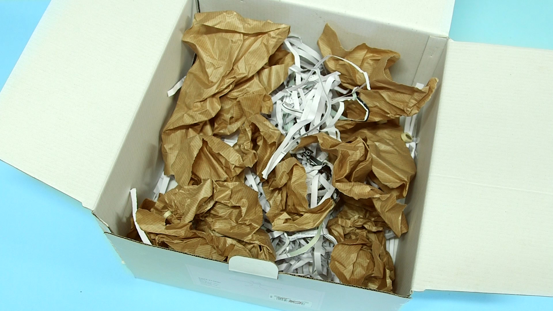 Box with rolled up and shredded paper to demonstrate destruction box
