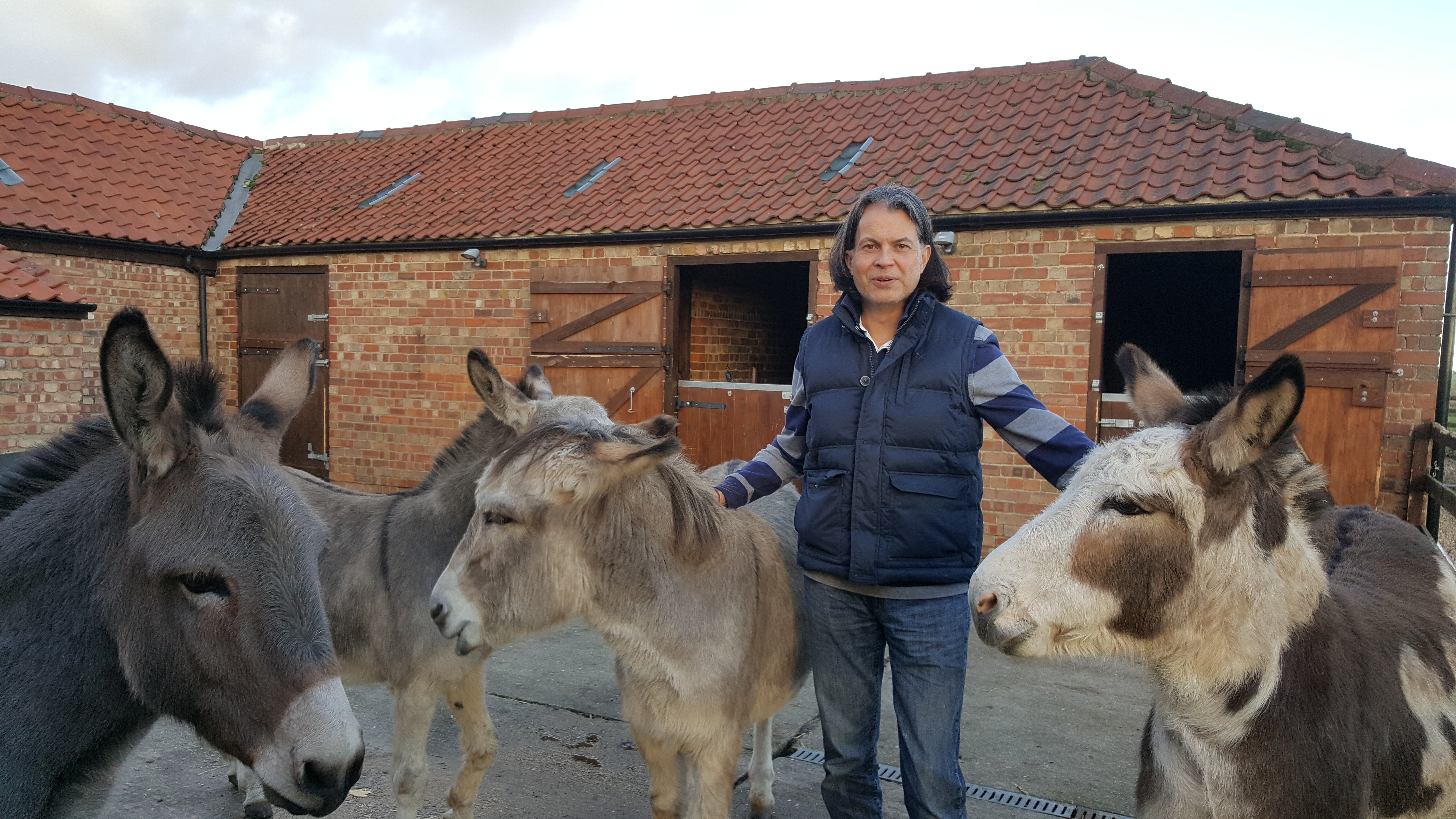 Trustee Chris Martin stood with donkeys in a yard