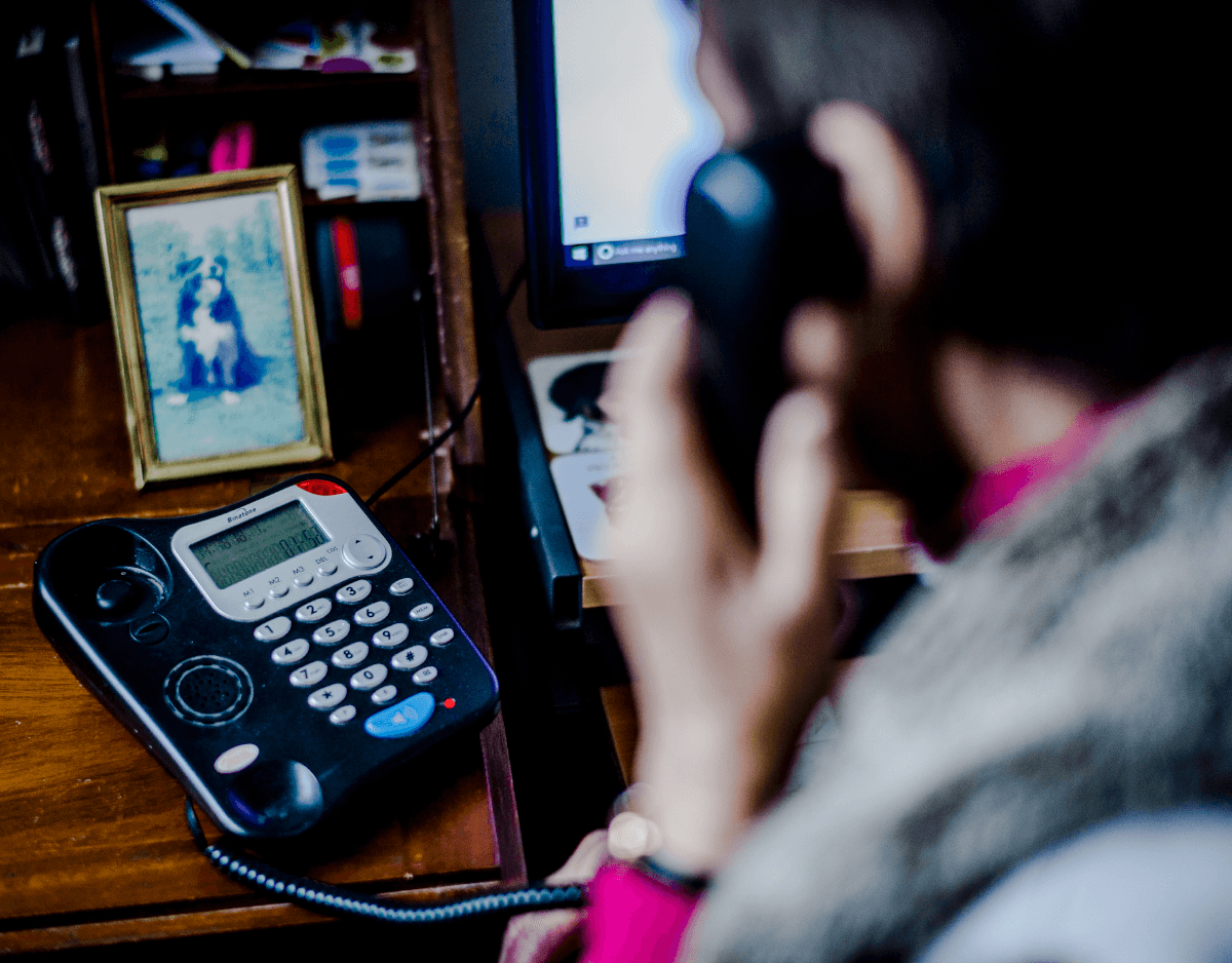 Woman on house phone with phone in clear shot