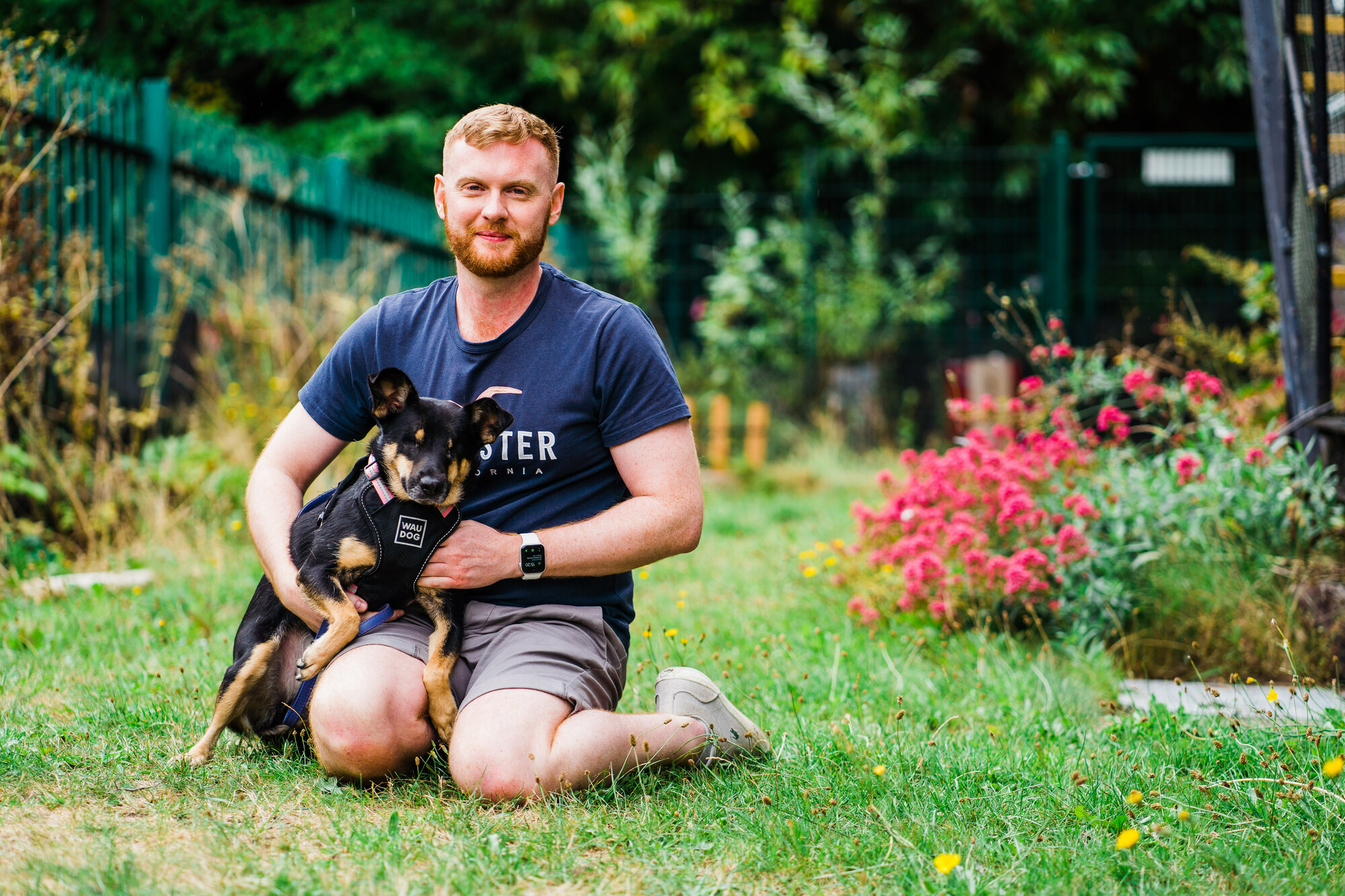 Dog Lucy snuggles up to owner Liam, who smiles at the camera with tears in his eyes