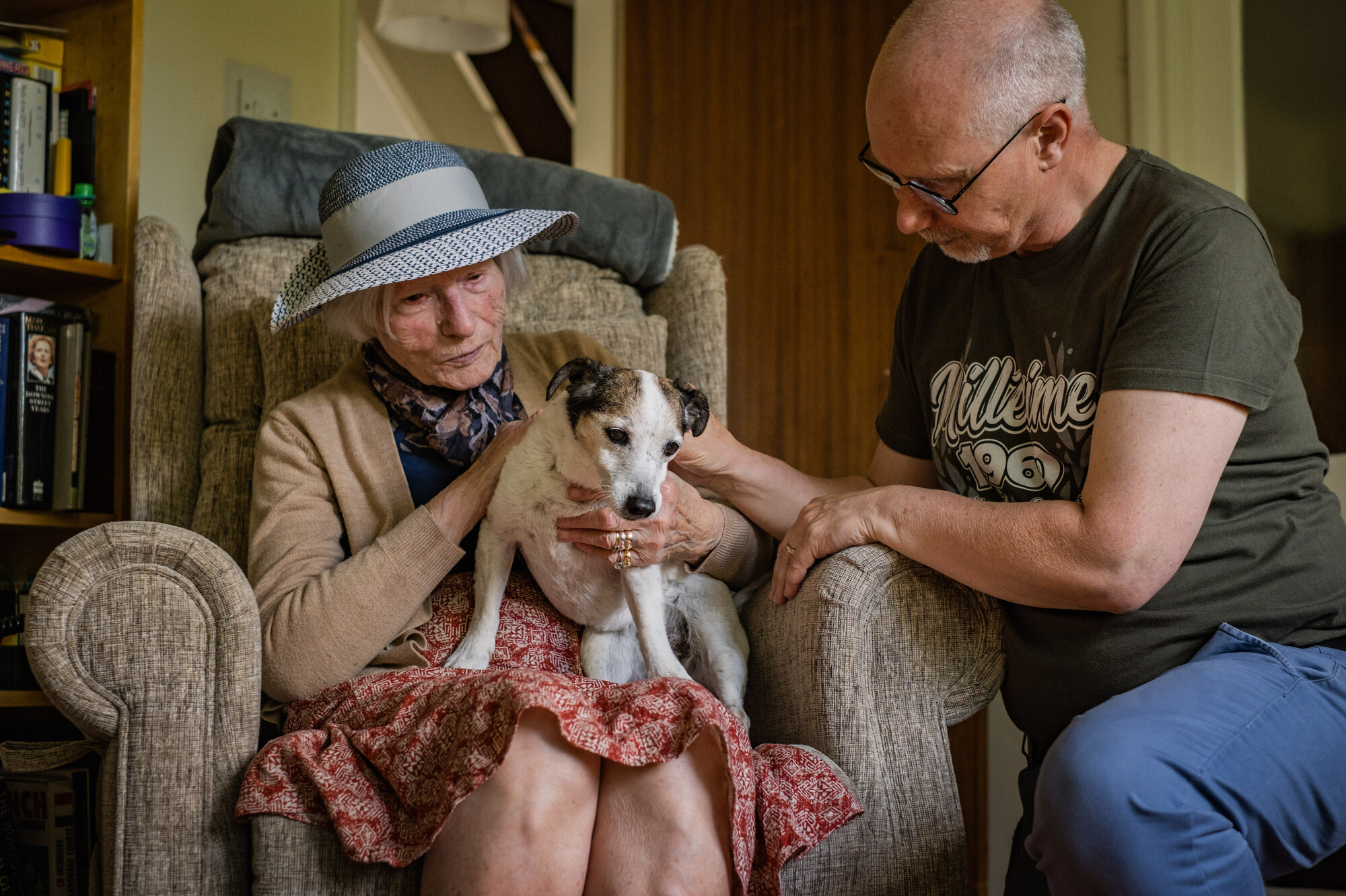 elderly dog Libby sitting on her new owner's lap in her new home