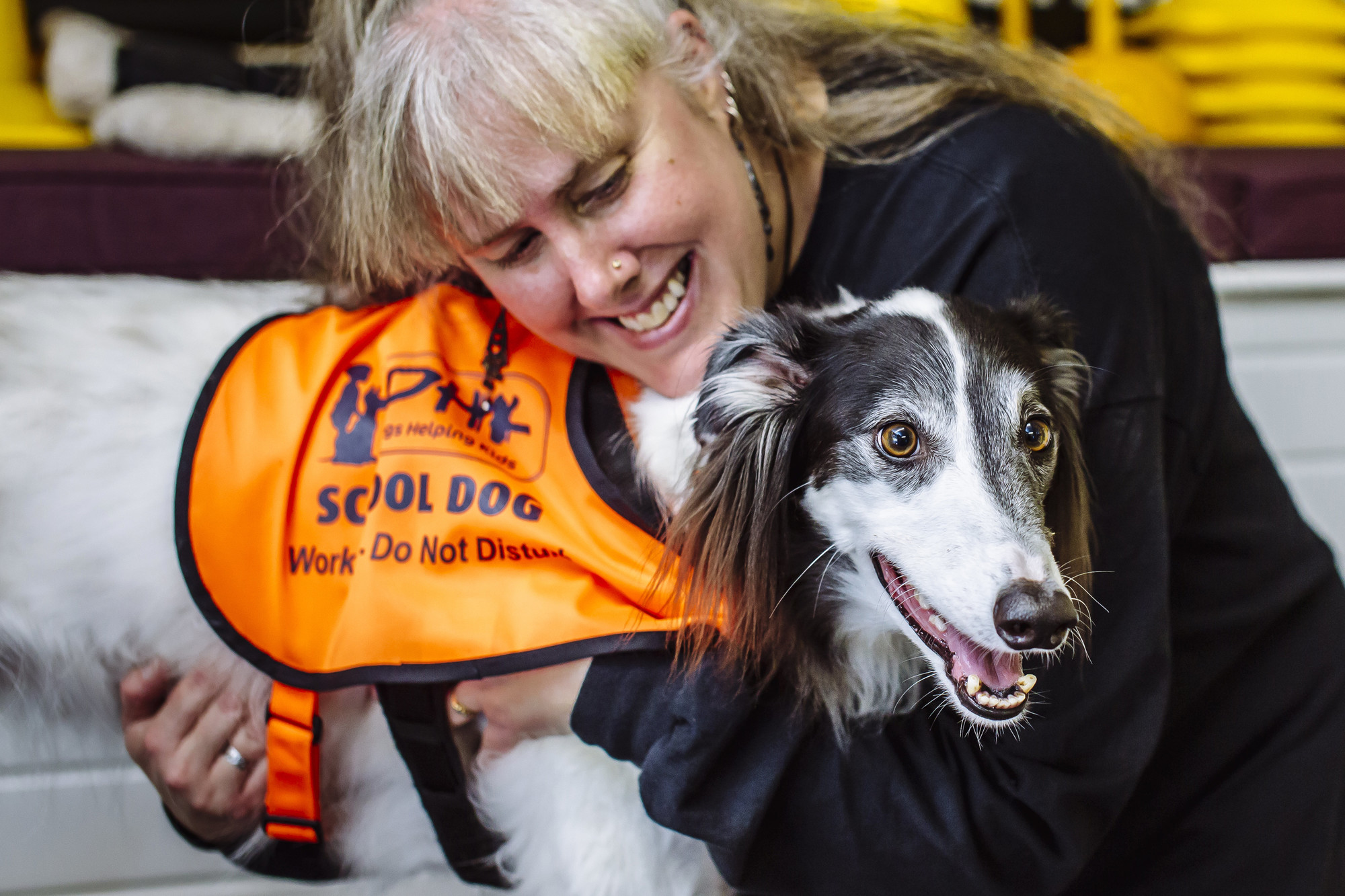 Tracey hugs Vader, wearing his orange DHK vest.