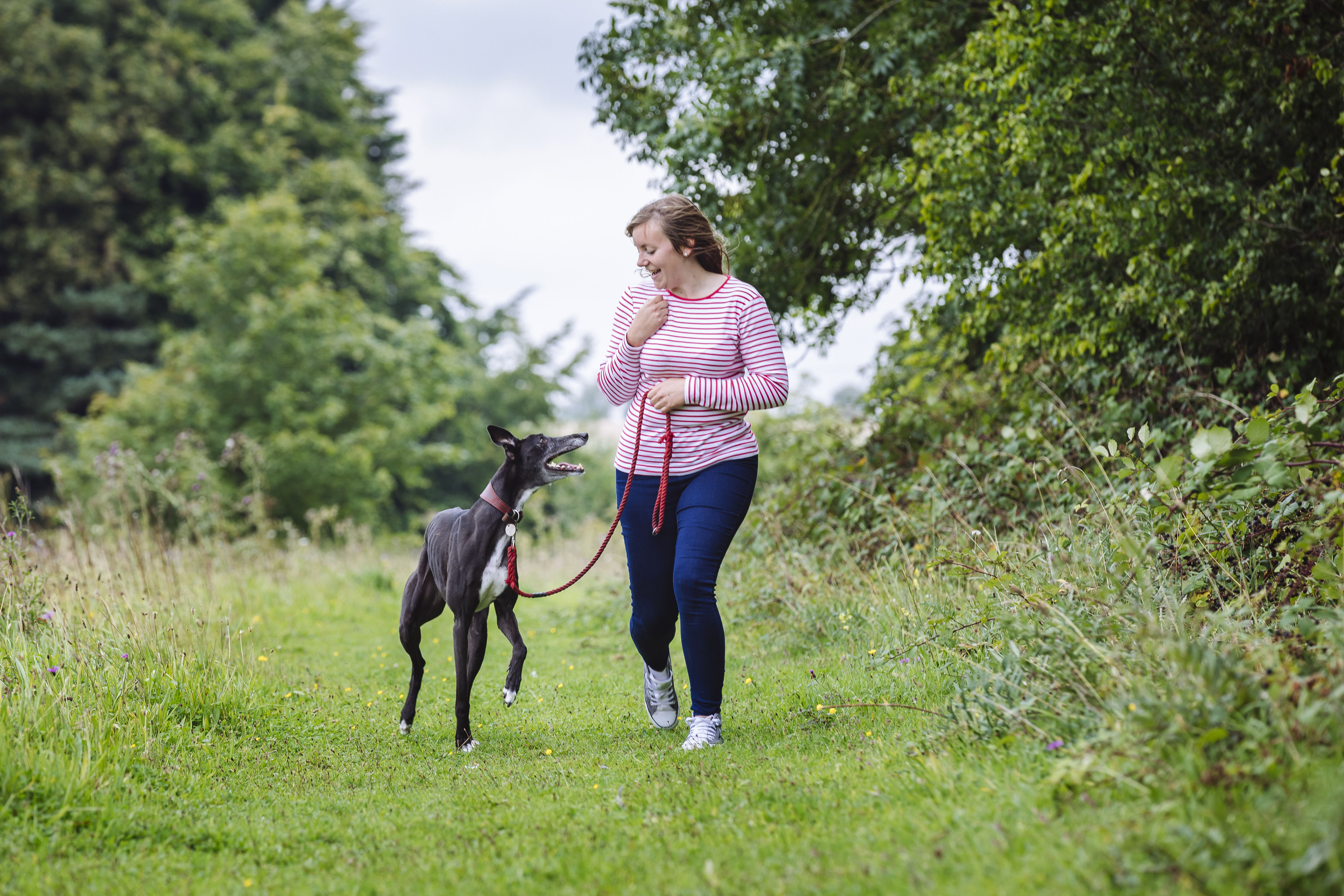 Pip walks alongside his owner Stacey and they smile at each other