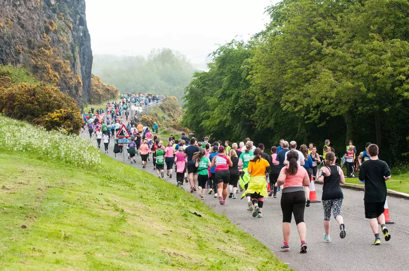 An image showing runners running through Edinburgh as part of the Edinburgh Half Marathon