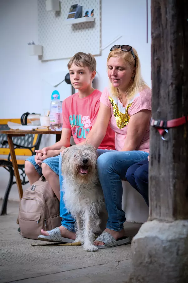 Evgenia sitting with Nika and son Arkadiy outside the clinic