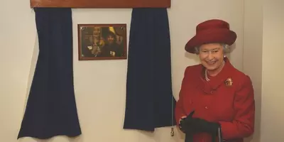 The Queen stands next to a gold plaque at the refurbished Victoria animal hospital in London