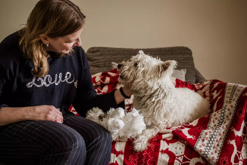 Westie Hamish and owner Katherine on the sofa together