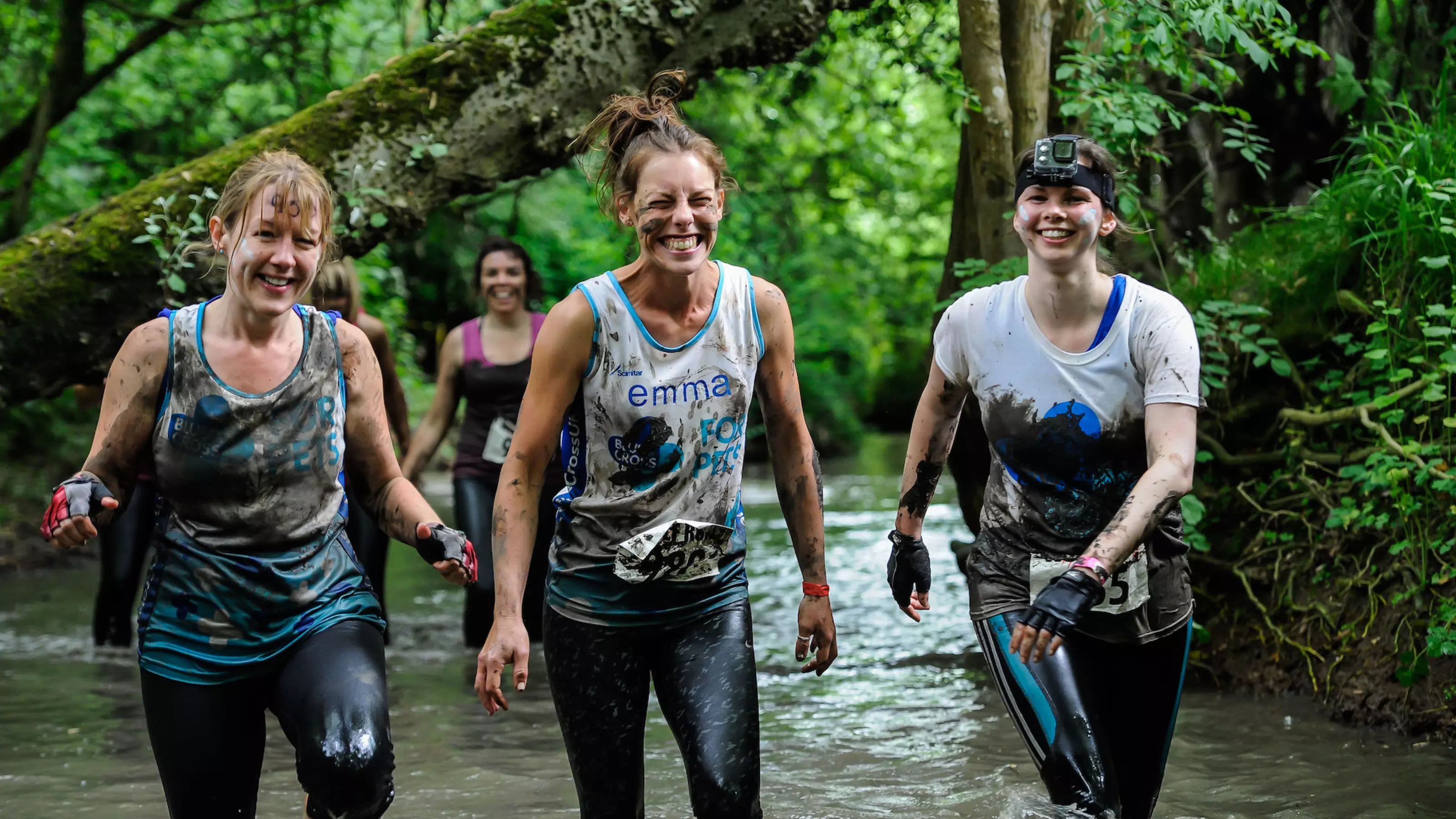 Three women running through river
