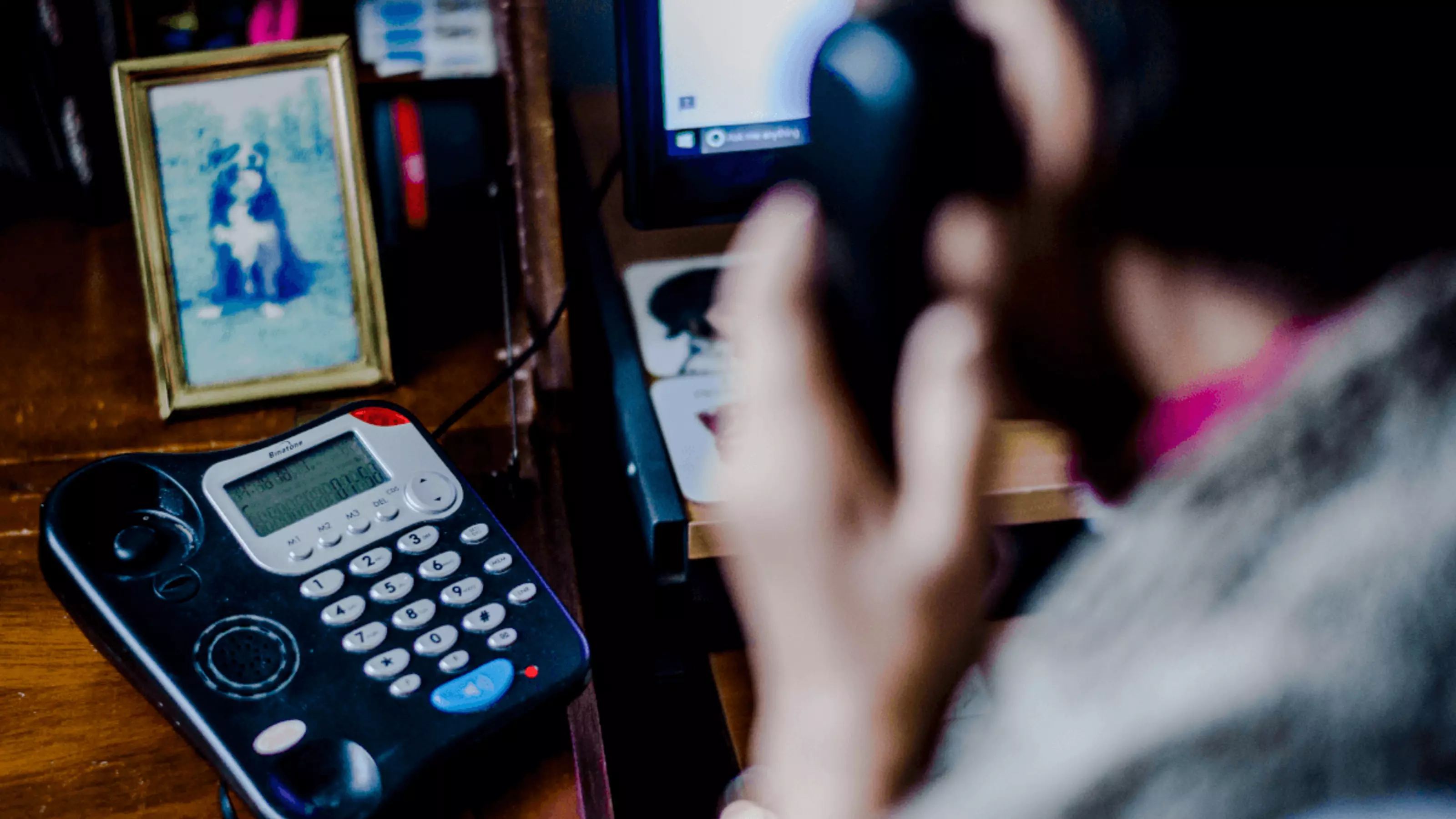 Woman on house phone with phone in clear shot