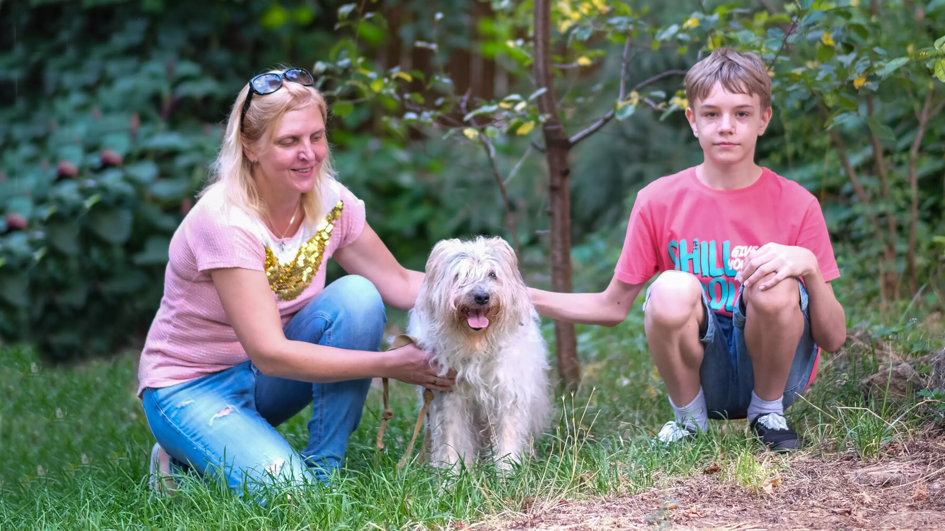 Evgenia and Arkadiy with dog Nika in the middle on grass