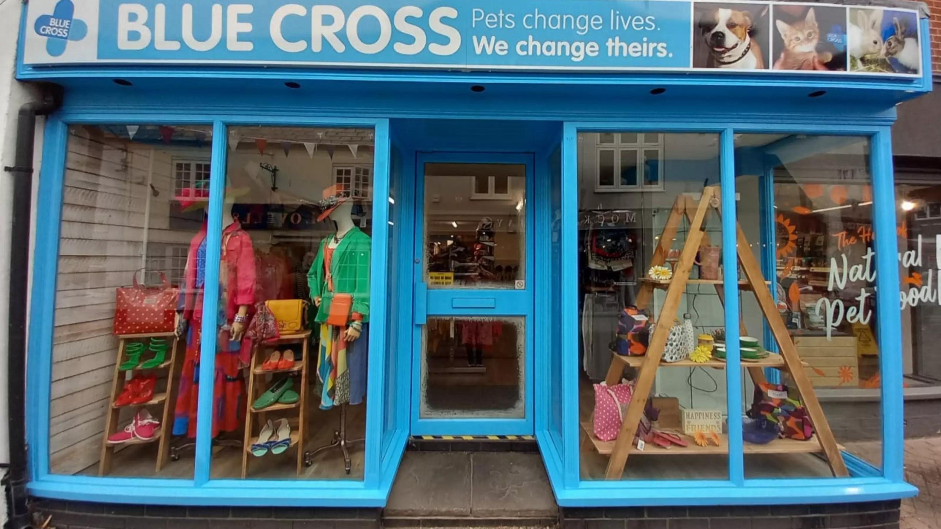 Front of the Hythe charity shop store featuring clothes, bags and shoes in the shop front window