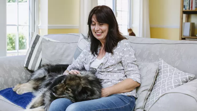 Jackie Buckle with her dog sitting on the sofa