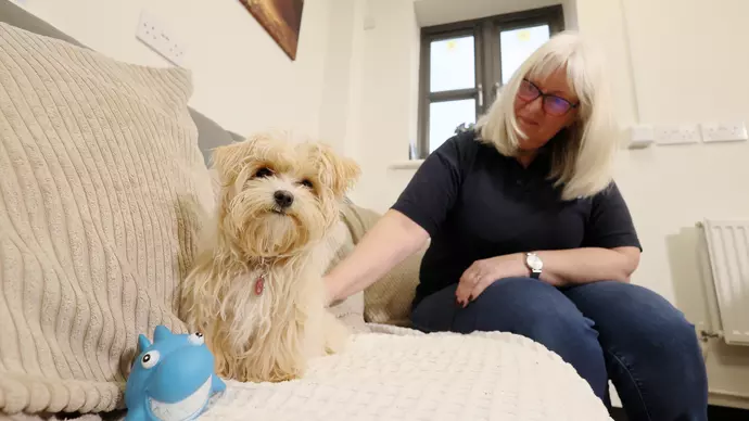 Martha sitting on a cream sofa with foster carer Jenny