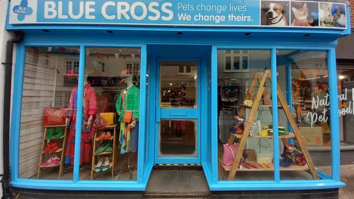 Front of the Hythe charity shop store featuring clothes, bags and shoes in the shop front window