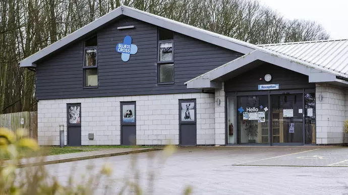 Grey and white building with Blue Cross signage