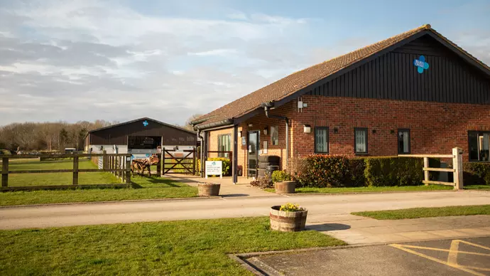 Red brick building with a grass field on the left