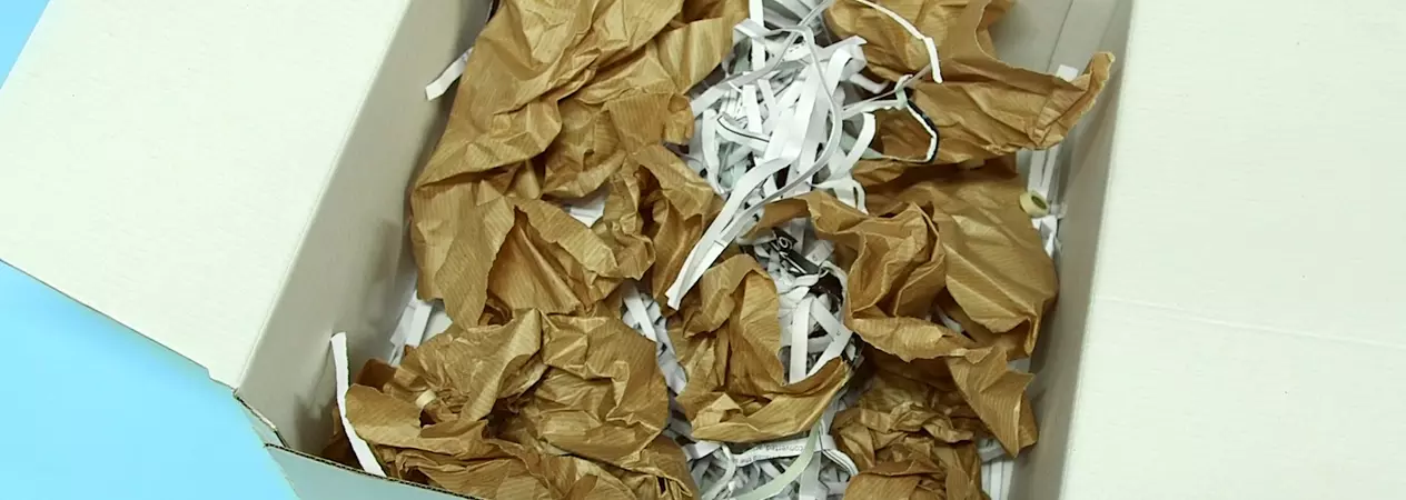 Box with rolled up and shredded paper to demonstrate destruction box