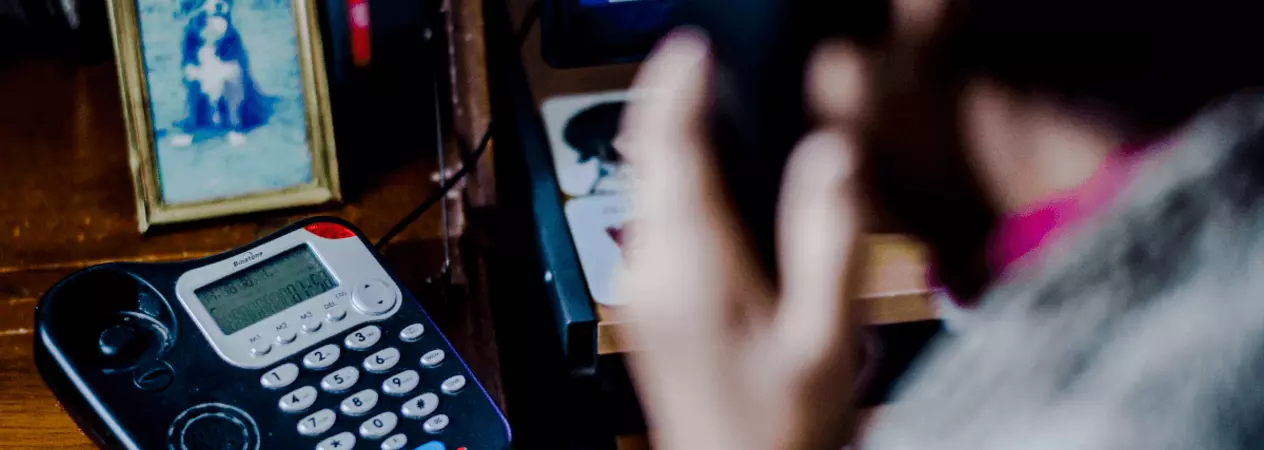 Woman on house phone with phone in clear shot