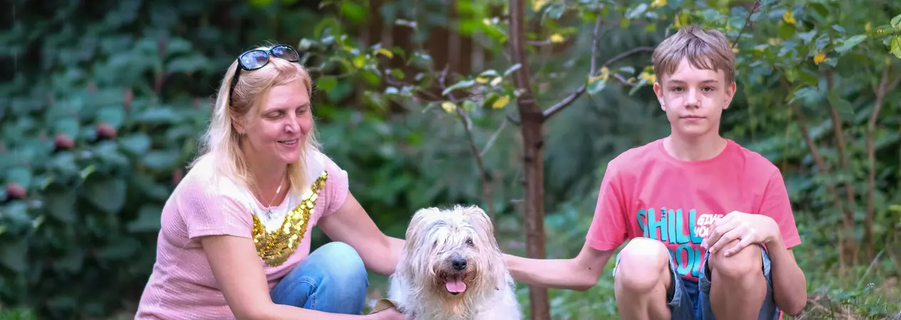 Evgenia and Arkadiy with dog Nika in the middle on grass