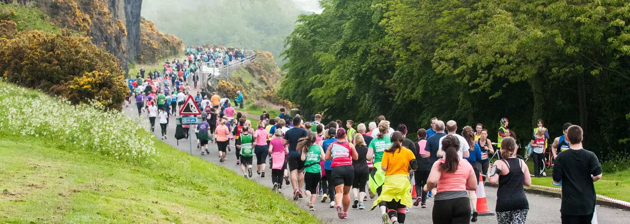 An image showing runners running through Edinburgh as part of the Edinburgh Half Marathon
