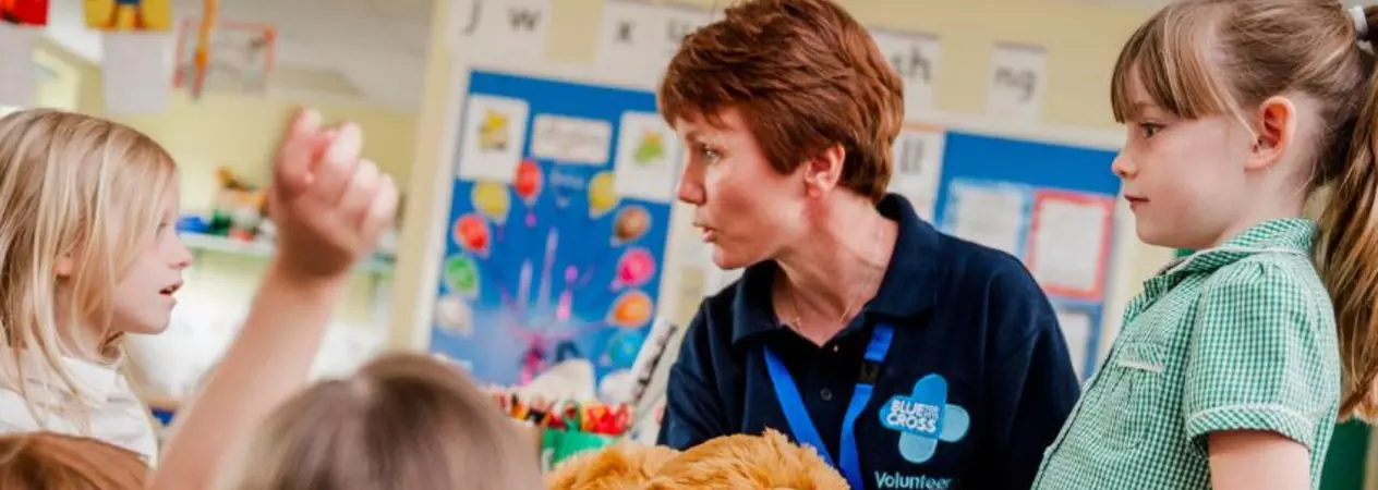 An education volunteer presenting a school talk to young children in a primary school classroom