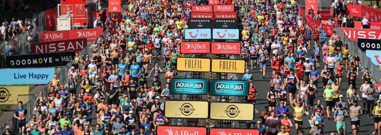 Runners participating in the Great North Run. There are banners for sponsorships.