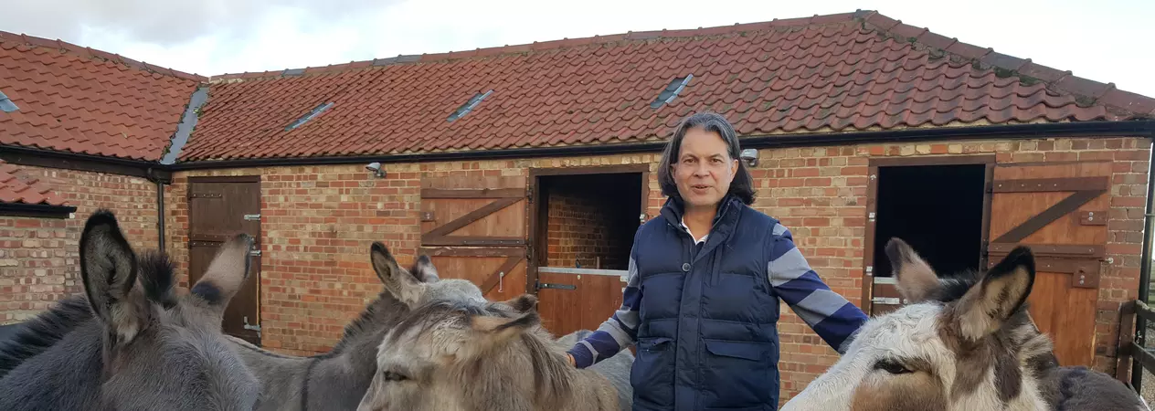 Trustee Chris Martin stood with donkeys in a yard