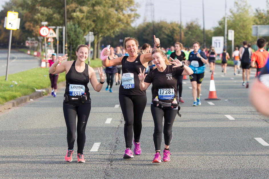 Three young women running as part of the Manchester Half marathon 